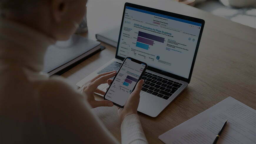 Young woman looking at both her phone and laptop | Health Quality Alberta primary healthcare panel reports